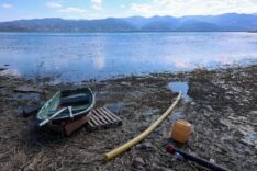 Göl kenarında eski tekne, su pompası ve doğa manzarası, doğal güzellikler ve su aktiviteleri ile ilgili rekabetçi SEO içerik.